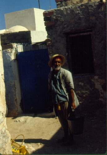 Portrait en pied d'un homme âgé avec chapeau de paille dans les rues de la hara Kebira, Djerba, Tunisie